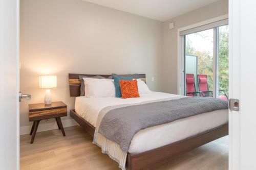 a bedroom with a large bed and a window at Coffee With A View, Brand New One Bedroom At Sooke Harbour in Sooke