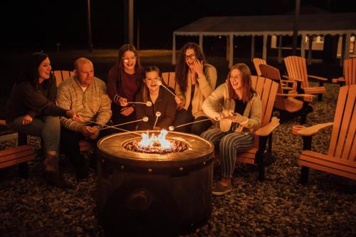 a group of people sitting around a fire pit at 4411 Inn & Suites in Michigan City