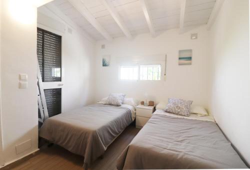 Duas camas num quarto com paredes brancas e uma janela em Casa Neptuno Spainsunrentals 1205 em Nerja