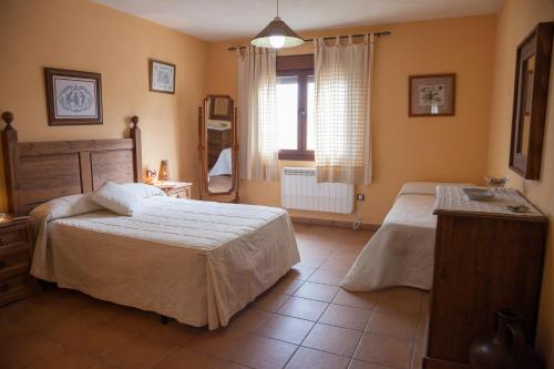 sypialnia z 2 łóżkami i oknem w obiekcie Casas Rurales Arroal w mieście Sotoserrano