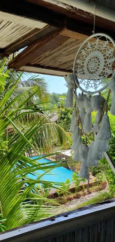 a chandelier hanging from a roof with a pool at Hotel ECOLODGE LE RAVORAHA in Sainte Marie