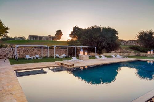 a swimming pool with chairs and a house at Podere Santa Chiara in Otranto