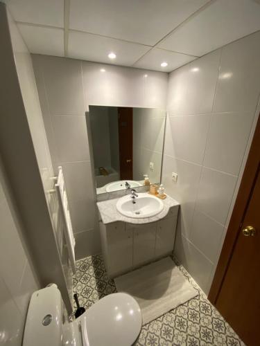 a white bathroom with a sink and a mirror at NÓRDIKA - Appartement chaleureux 10' des pistes in El Tarter