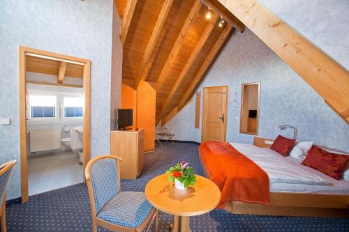 pokój hotelowy z łóżkiem, stołem i krzesłami w obiekcie Hotel Post Jungingen w mieście Jungingen