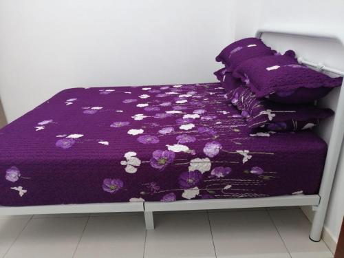 關丹的住宿－HOMESTAY KUANTAN INDERA SEMPURNA 2，一张带紫色棉被和枕头的床