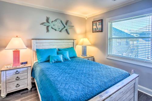 um quarto com uma cama azul, 2 candeeiros e uma janela. em Coastal Condo with Pool Access - Walk to Apache Pier em Myrtle Beach