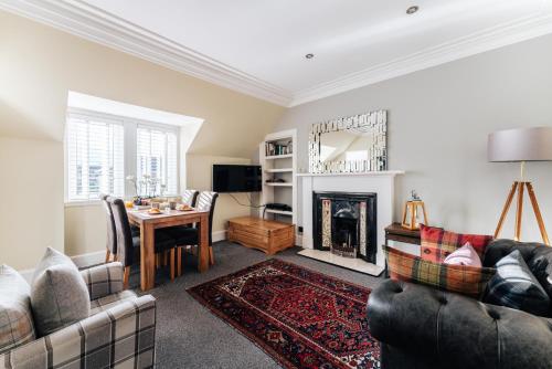 a living room with two couches and a fireplace at Luxury Inverness central apartment private parking in Inverness
