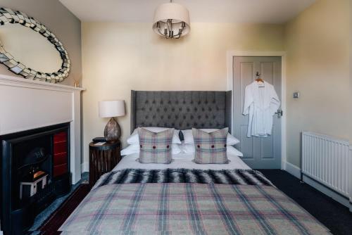 a bedroom with a bed with a blanket and a mirror at Luxury Inverness central apartment private parking in Inverness
