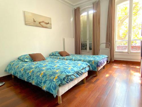 deux lits dans une chambre avec parquet dans l'établissement L'appartement Notre-Dame, à Paris