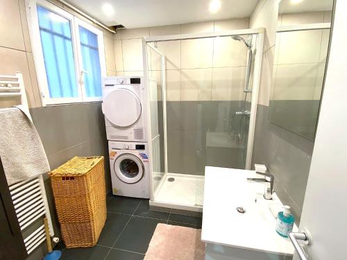 une salle de bain avec une machine à laver et un lave-linge dans l'établissement L'appartement Notre-Dame, à Paris