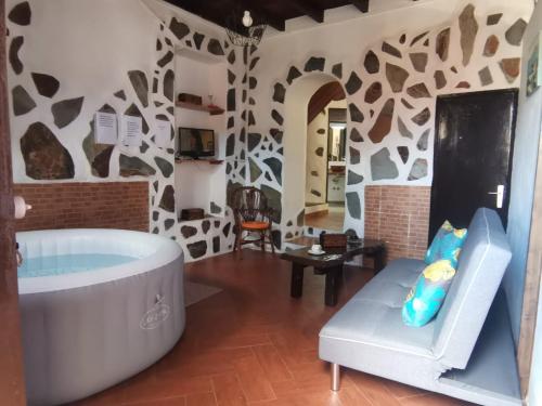 baño grande con bañera y silla en Casita Rural con Jacuzzi climatizado. en Los Realejos