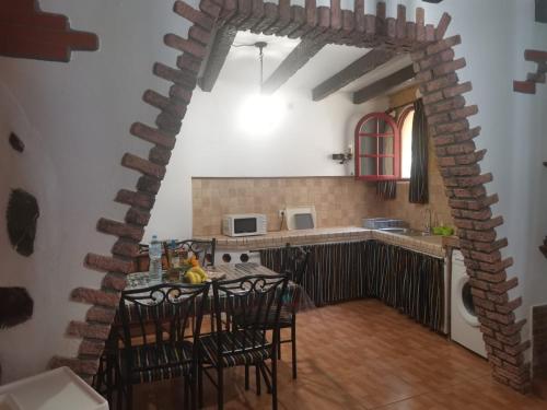 kuchnia ze stołem z krzesłami i ceglaną ścianą w obiekcie Casita Rural con Jacuzzi climatizado. w mieście Los Realejos