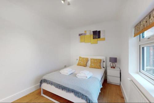um quarto branco com uma cama e uma janela em New Spacious 1 bed studio flat in Aldgate em Londres