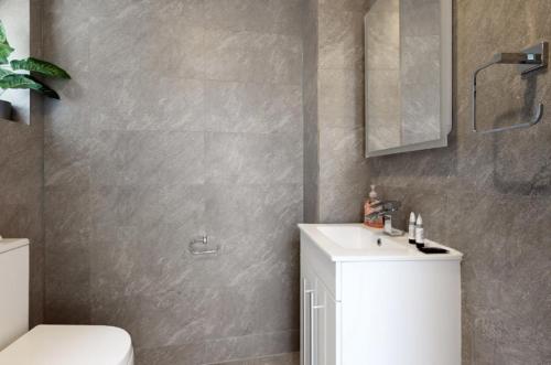 uma casa de banho com um lavatório branco e um WC. em New Spacious 1 bed studio flat in Aldgate em Londres