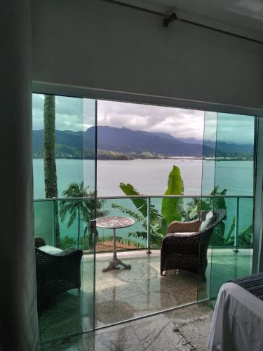 a room with a view of the water at Suites na Casa da Praia in Ilhabela