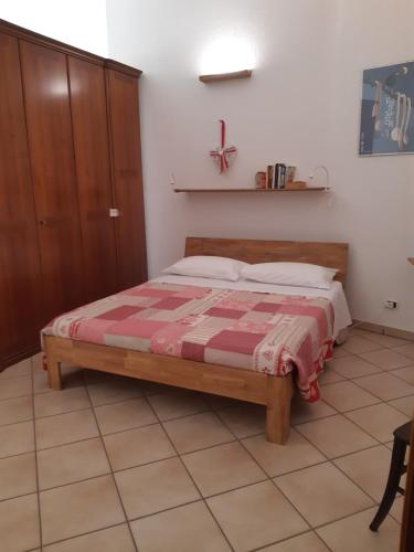 Schlafzimmer mit einem Bett mit einer roten und weißen Decke in der Unterkunft Il Pesco in Nus
