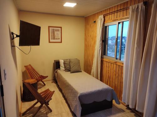 Un dormitorio pequeño con una cama y una ventana. en ECO.MAR, en Punta del Diablo
