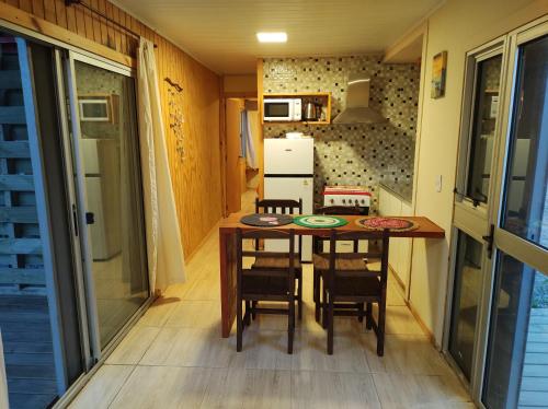 una cocina con mesa y sillas en una casa pequeña en ECO.MAR, en Punta del Diablo