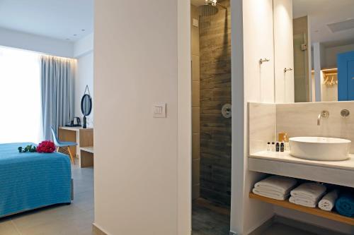 a bathroom with a sink and a shower at Oasis Beach Hotel in Skala