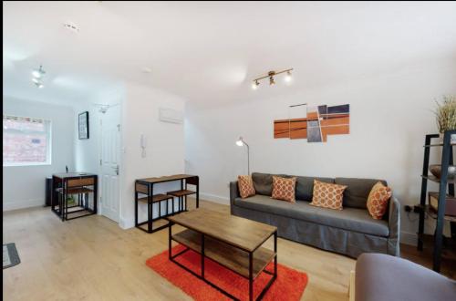 a living room with a couch and a table at Modern split level 1 bedroom flat in Aldgate in London