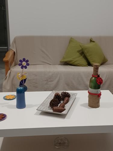 una mesa con una bandeja de donuts y una botella de vino en Andri' s place en Nea Paphos
