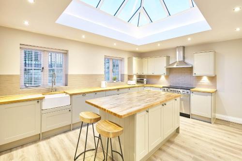 a kitchen with a skylight and a kitchen island with stools at Host & Stay- Graham House in Osmotherley