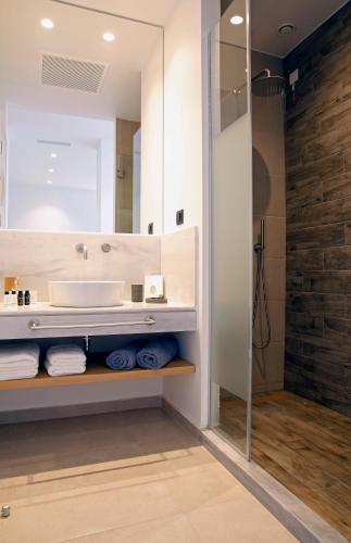 a bathroom with a sink and a mirror at Oasis Beach Hotel in Skala
