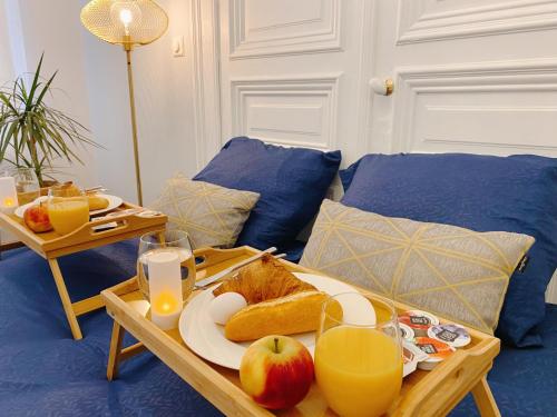 einen Tisch mit einem Tablett mit Brot und Äpfeln darauf in der Unterkunft CoCo Romantic - apartment in most trendy central hotspot of Antwerp in Antwerpen