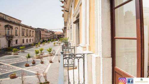 un balcone di un edificio con piante in vaso di Homes4Holidays - Teatro Massimo a Catania