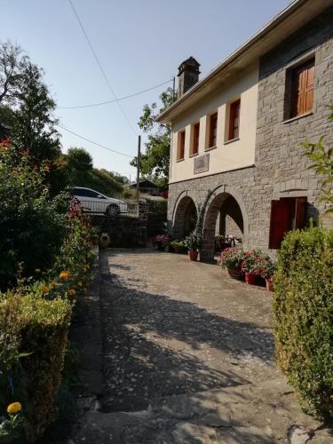 a stone building with a pathway leading to it at Hotel Tymfi in Tsepelovo