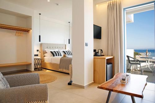 a bedroom with a bed and a living room at Oasis Beach Hotel in Skala