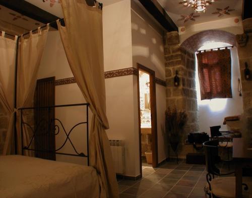 Baños de RiojaにあるCasa Rural Medieval Torre Fuerte S.XIIIのベッドルーム1室(ベッド1台、テーブル付)