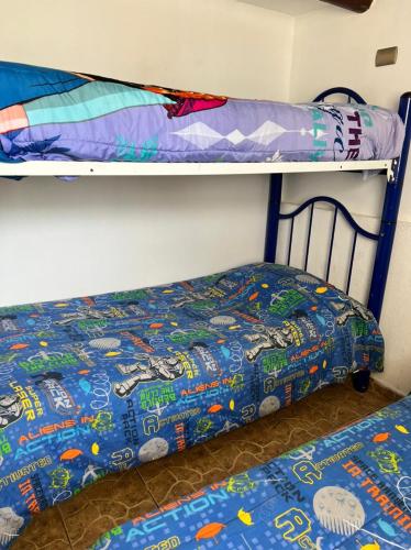 a bedroom with two bunk beds and a bedspread at Cabañas Costatour Quintero in Quintero