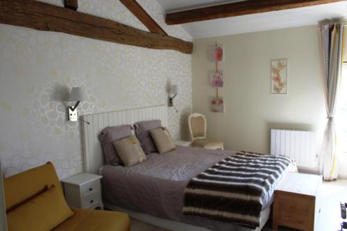 une chambre avec un lit et une chaise dedans dans l'établissement Flore des Marais, à Vix