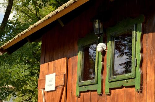 a house with two windows and a sign on it at Őrálló Szer in Őriszentpéter