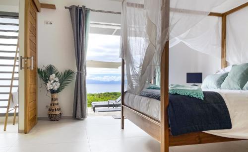 Villa Belle Galante في ليه باسي: غرفة نوم مع سرير وإطلالة على المحيط