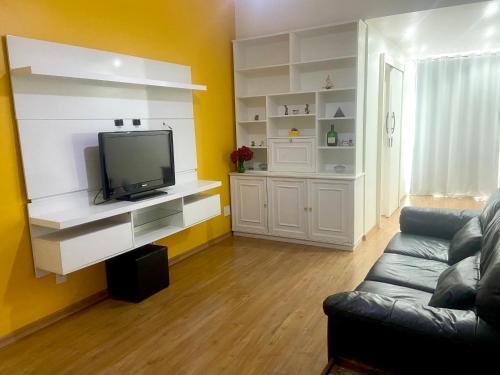 Apartamento completo na praia de Copacabana 02 Suites com vista mar em andar alto, ar, wifi , netflix, pauloangerami RMVC18 في ريو دي جانيرو: غرفة معيشة مع أريكة وتلفزيون