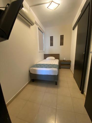 a small bedroom with a bed in a room at FRENTE PLAYA vista al mar, PISCINA DE USO EXCLUSIVO in Boca del Río