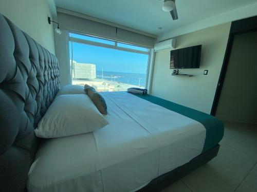 a bedroom with a large bed with a large window at FRENTE PLAYA vista al mar, PISCINA DE USO EXCLUSIVO in Boca del Río