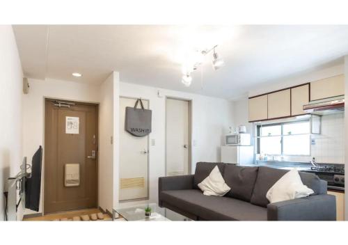 a living room with a couch and a kitchen at Union Shin-Osaka 3F - Vacation STAY 12037 in Osaka