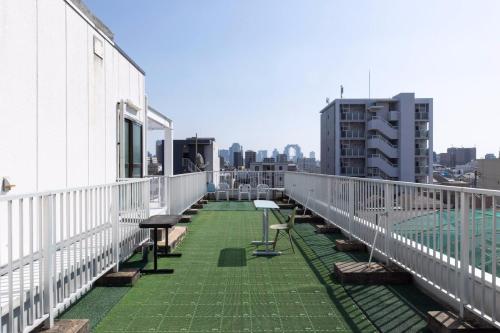 a balcony with tables and benches on a building at Union Shin-Osaka 3F - Vacation STAY 12037 in Osaka