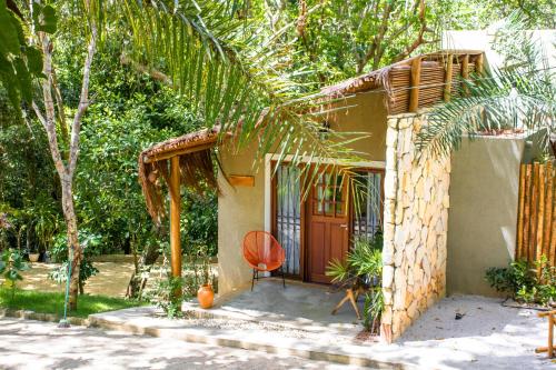 una pequeña casa con una silla delante en SITIO VILLA DA MATA, en São Miguel dos Milagres