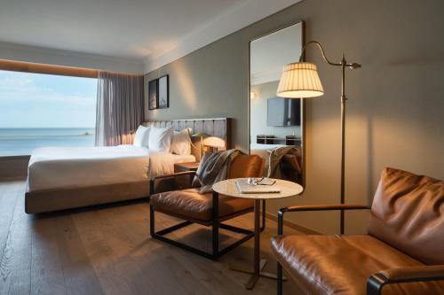 a hotel room with a bed and a table and a couch at Costanero Hotel Montevideo - MGallery Collection in Montevideo