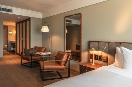 a hotel room with a bed and a mirror at Costanero Hotel Montevideo - MGallery Collection in Montevideo