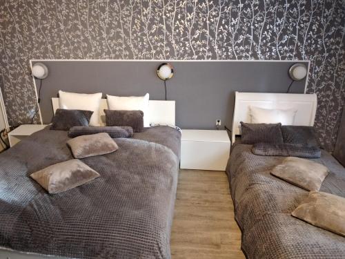 1 dormitorio con 2 camas y pared con papel pintado en Vila TANIA, en Predeal