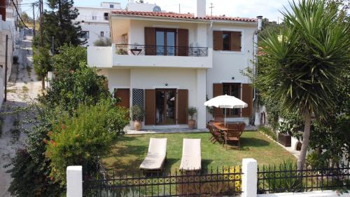 a house with a table and chairs and an umbrella at Skiathos Town House in Skiathos