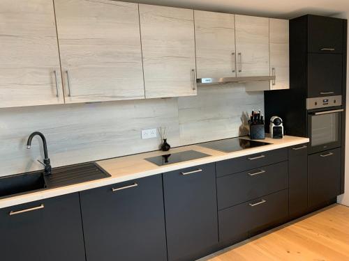 a kitchen with gray cabinets and stainless steel appliances at Villa Le Brame in Ciney