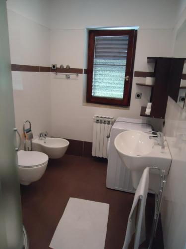 a bathroom with two sinks and a toilet and a window at Villa Kubo in Lovran