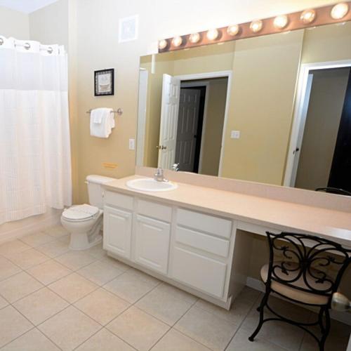 a bathroom with a sink and a mirror and a toilet at Condominium Apartment Close to Disney in Orlando Florida in Orlando