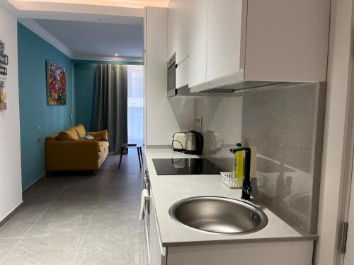 a kitchen with a sink and a living room at Apartments by Sliema promenade and beach in Sliema